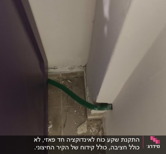 צינור ירוק בקיר עם שאריות טיח על הרצפה